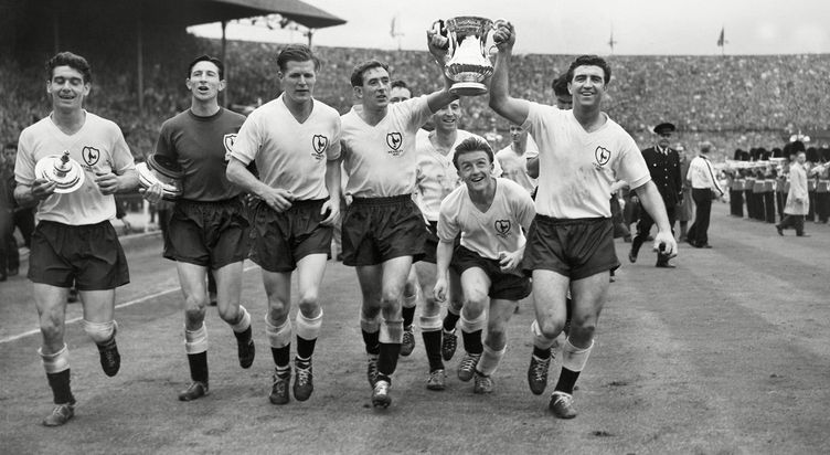 Terry Dyson ducks under the FA Cup held aloft by skipper Danny Blanchflower and fellow goalscorer Bobby Smith after the 1961 FA Cup Final